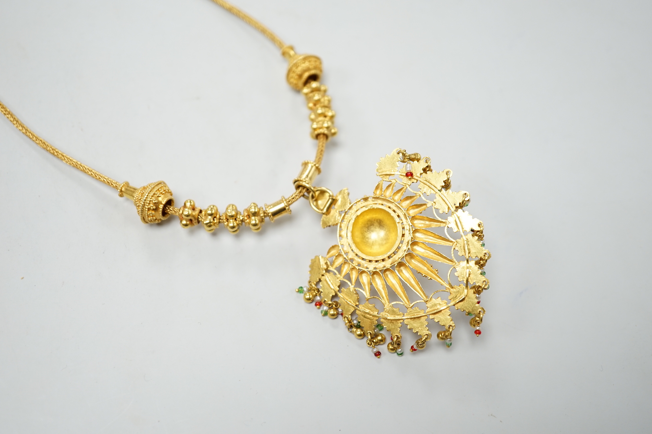 An Indian yellow metal two colour enamel and seed pearl set drop pendant necklace, overall, 45cm, gross weight 40.5 grams.